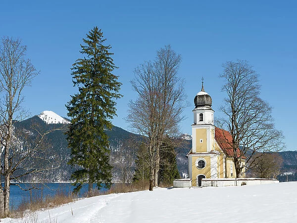 Church Sankt Margareth at Zwergern Spitz. Lake Walchensee near village Einsiedl in the snowy Bavarian Alps. Germany, Bavaria Date: 24-03-2021