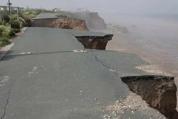 Collapsed tarmac road following cliff erosion on coast East Newton East Riding of Yorkshire UK