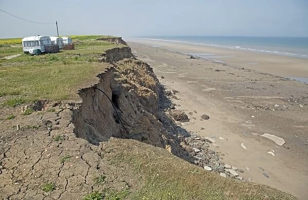 Collapsing tarmac road at cliff edge on coast road Skipsea East Riding of Yorskhire UK
