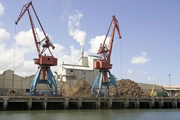 Cranes on quayside unloading scrap metal into trucks for reprocessing Bilbao docks Spain