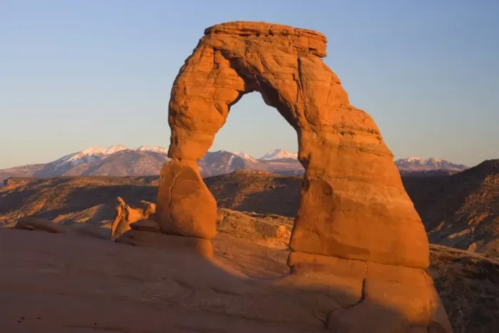 Framed Print : Delicate Arch - delicately sculptured sandstone arch standing in front of snow-covered Manti-La Sal Mountains on a slickrock slope. In late evening - Arches National Park, Utah, USA Framed Print : Delicate Arch - delicately sculptured sandstone arch standing in front of snow-covered Manti-La Sal Mountains on a slickrock slope. In late evening - Arches National Park, Utah, USA
