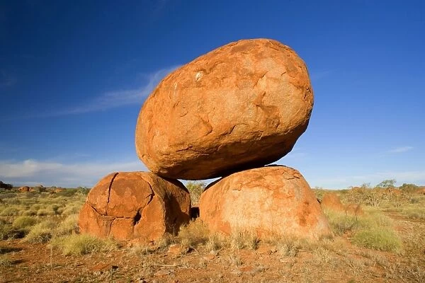 Devils Marbles - a balanced rock of red granite is situated on top of two boulders - Devils Marbles Conservation Area, Northern Territory, Australia