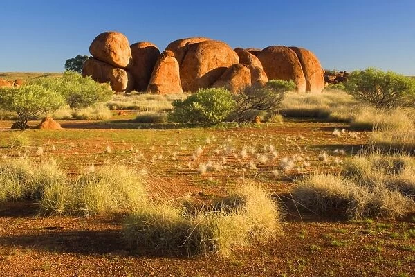 Devils Marbles - several circular shaped marbles of red granite situated amidst grassy bushland - Devils Marbles Conservation Area, Northern Territory, Australia