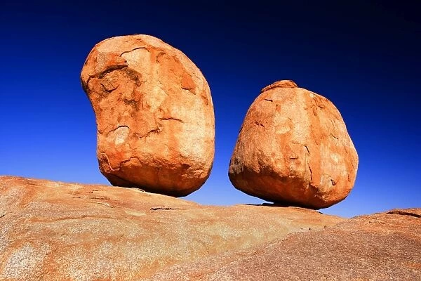 Devils Marbles - two nearly perfectly circular shaped boulder of red granite balanced on bedrock - Devils Marbles Conservation Area, Northern Territory, Australia