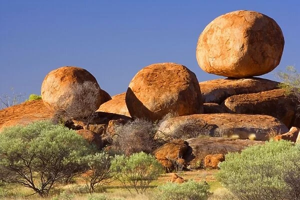 Devils Marbles - three nearly perfectly circular shaped boulders of red granite balanced on still bigger rocks - Devils Marbles Conservation Area, Northern Territory, Australia