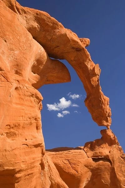 Ephemeral Arch - fragile and delicately sculptured arch of red sandstone - arch and its base are supported only by a little piece of rock the size of a thumb