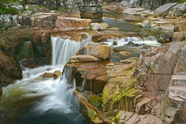 Etive river cascades water flowing over red rocks Etive River, Glen Etive, Glencoe area, Highlands, Scotland, UK
