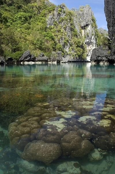 The exit (between the rocks) of a Big Lagoon of El Nido Minilok island, corals are visible in clear waters. Near El Nido Minilok resort, El Nido, Palawan, Philippines. February. Ph41. 0933