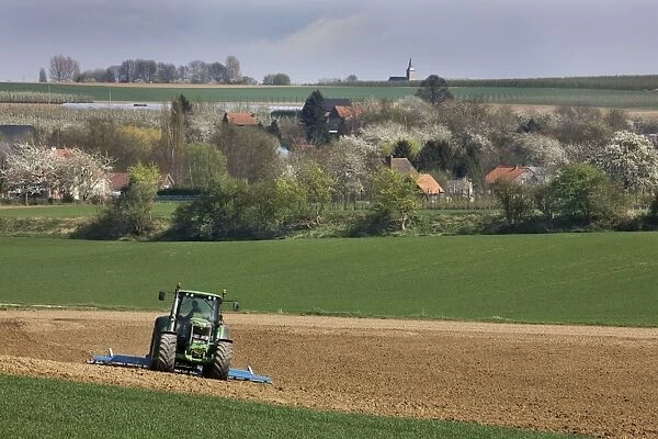 Farming - agricultural landscape with tractor ploughing