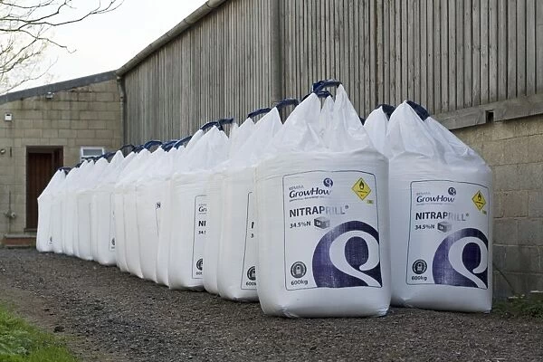 Fertiliser - stack of large white bags of farm Nitraprill nitrogen fertiliser outside barn. Cotswold farm - UK