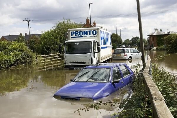 Flooding - cars and lorries partly submerged on flooded road into Newtown, Tewkesbury, Gloucestershire, UK following unprecedented flooding of Rivons Avon and Severn above 1947 level