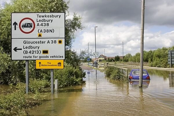 Flooding - cars partly submerged on flooded in Newtown, Tewkesbury Gloucestershire, UK with road sign to Watermeadows following unprecedented flooding of Rivons Avon and Severn above 1947 level