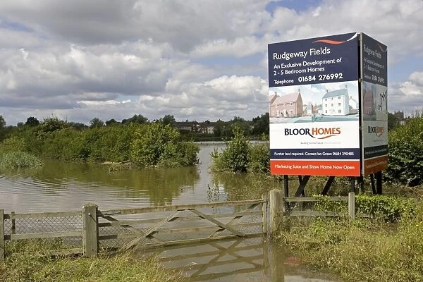 Flooding - Large bill board adverting exclusive development of new houses on inundated flood plain Newtown, Tewkesbury, Gloucestershire, UK following unprecedented flooding of Rivers Severn and Avon July 2007