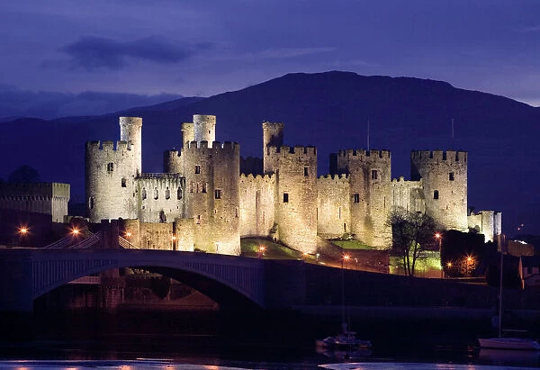 GUY-97. Conwy Castle - being lit up at dusk - November - North Wales - UK