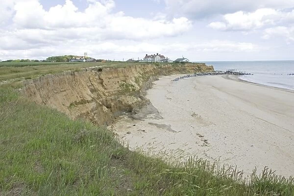 Houses on edge of severely eroded cliffs Happisburgh North Norfolk Coast UK