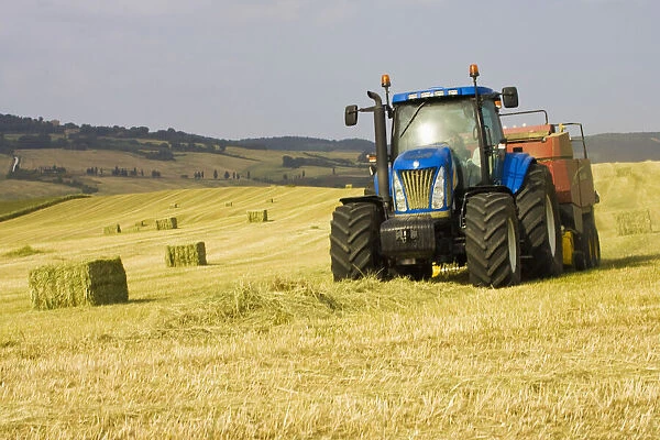 Italy, Tuscany, Tractor Harvesting Hay in