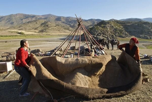 Kazakh herders erecting tent on there journey to