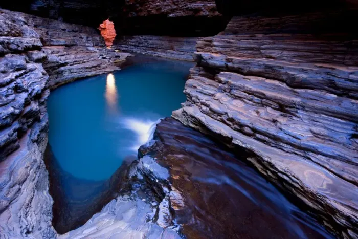 Framed Print : Kermit's Pool - a stream is flowing down Hancock Gorge, surrounded by steep, red and very terraced ciffs, into Kermit's Pool. Because of it's depth the pool's water appears an amazing deep blue