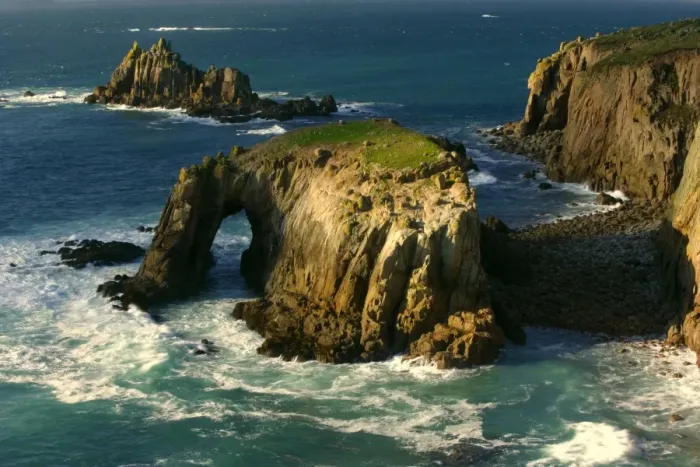 Framed Print : Lands End rugged coastline with rock arch in last evening light Lands End, Cornwall, England, UK