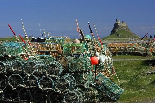 Lindisfarne, Holy Island-stacked lobster pots and view of castle, Northumberland UK