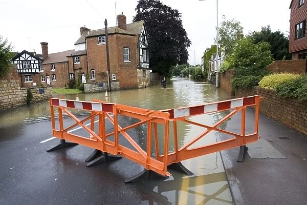 MAB-368. Woman walking along flooded road into Tewkesbury near Abbey