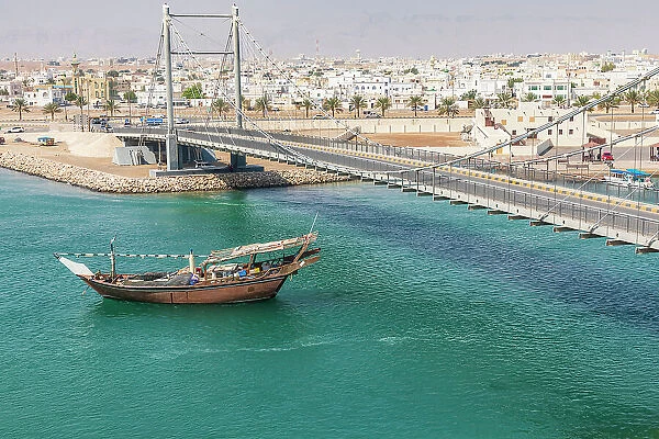 Middle East, Arabian Peninsula, Oman, Al Batinah South. Dhow passing under a suspension bridge. Date: 28-10-2019