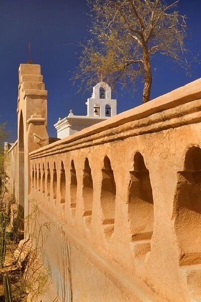 Mission San Xavier del Bac - beautiful archway, ornate wall and white bell tower of this famous mission in western style, near Tuscon - Tuscon, Arizona, USA