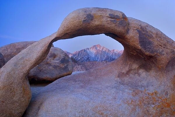 Mobius Arch - alpenglow on Lone Pine, one of the snow-capped mountains of the Sierra Nevada, seen through ock arch of red granite. At sunrise - Alabama Hills Recreation Area, California, USA