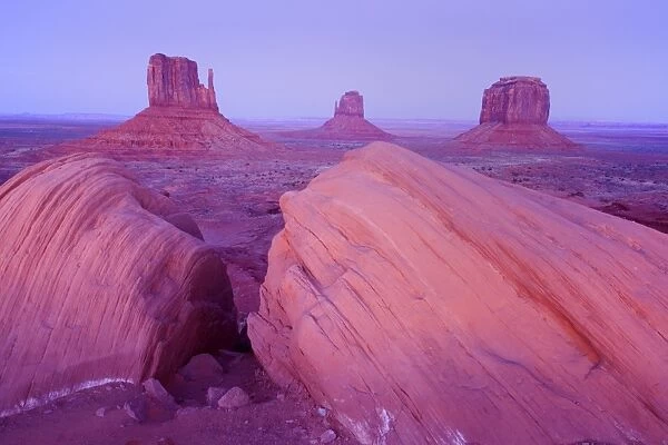 Monument Valley - panoramic view into Monument Valley with its famous sandstone buttes West Mittens, East Mittens and Merrick. At dusk - Monument Valley Tribal Park, Navajo Reservation, Arizona, USA