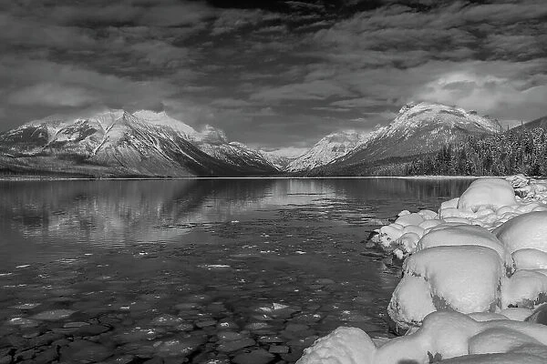Mountains reflect in wintry Lake McDonald in Glacier National Park, Montana, USA Date: 17-02-2021