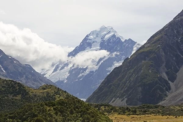 New Zealand - spectacular scenery of glacial valley with snow capped mountains and forested slopes in Aoraki Mount Cook National Park. Surrounded by snow covered mountains this spectacular wilderness area in South Island New Zealand ihas now been