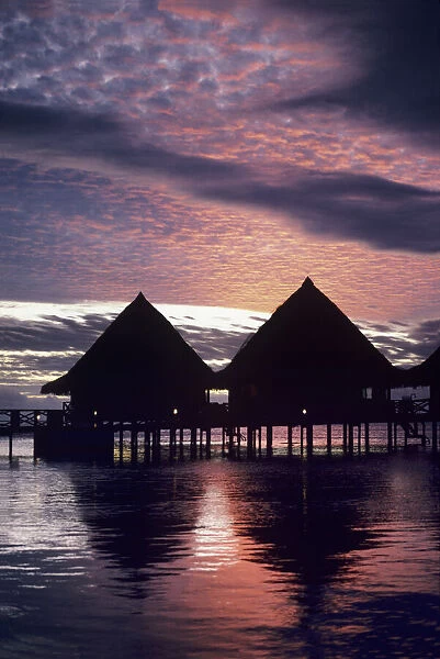 Overwater bungalows at sunset at Hotel Bali