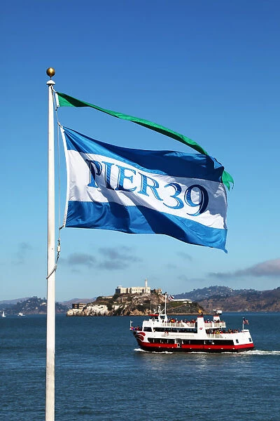 Pier 39 flag, sightseeing boat and Alcatraz prison