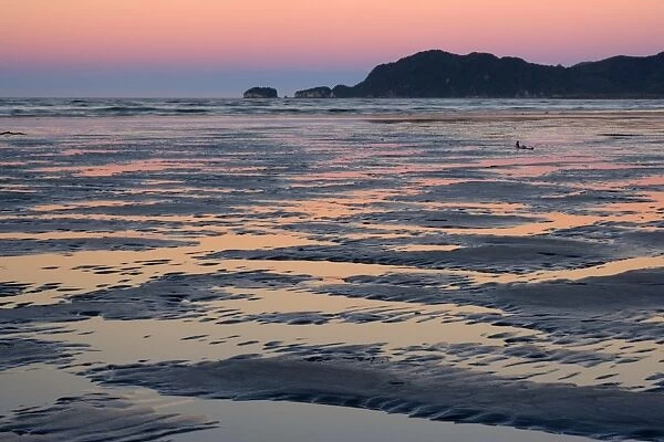 Pohara Beach colourful sky just after sunset reflected in water gathering between sand ripples at low tide Pohara, Golden Bay, Tasman District, South Island, New Zealand