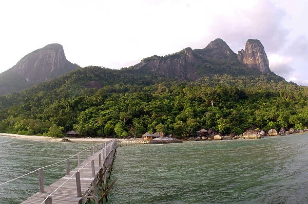 Rainforest, volcanic 'Twin Peaks' - Bukit Batu Sirau and Bukit Semukut peaks, and the Gunung Kajang peak on the left, a jetty and a wooden cabins of the 'Bagus Place Retreat' - a small private resort
