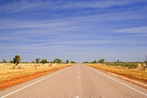 Road to nowhere - a perfectly straight bitumen road, which leads for hours and hours through dry bushland, in Western Australia's outback - Western Australia, Australia