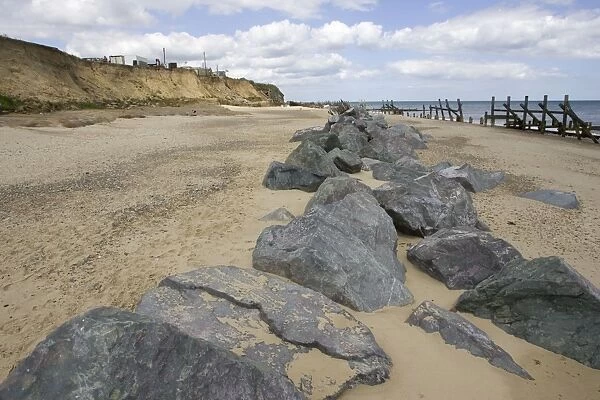 Rocks dumped on beach to reduce severe coastal erosion Happisburgh North Norfolk Coast UK