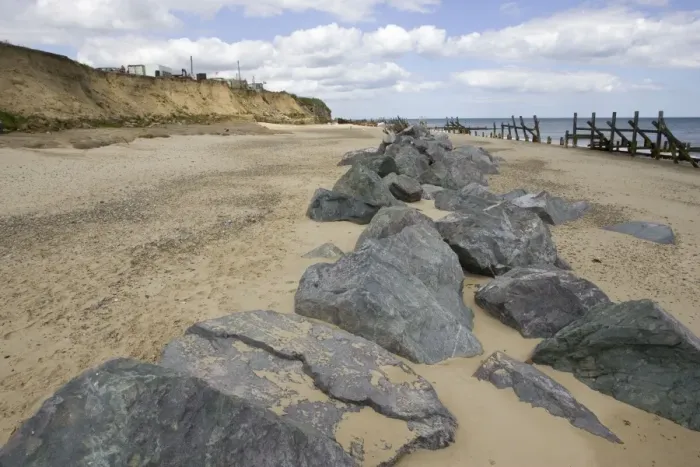 Framed Print : Rocks dumped on beach to reduce severe coastal erosion Happisburgh North Norfolk Coast UK