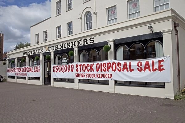 Sale notices in furnishing shop window offering big discounts - Cheltenham UK