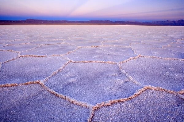 Salinas Grandes del Noroeste - mountains and dried-up salt lake showing a regular polygonal pattern created by salt crystals - at dusk - the salinas are located on an altitude of 3450 m above sea level on the so-called Altiplano - Prov