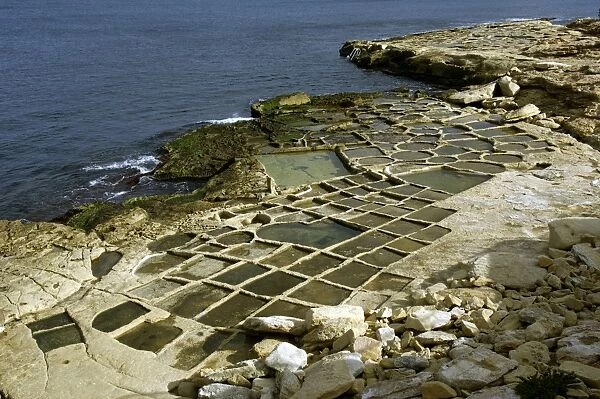 Salt pans at Marsaskala, Malta. Look like shallow trays cut into the stone. They were created by the Knights in the 17th century. There are a number of salt pan sites around the Island although most are disused - the site in this picture