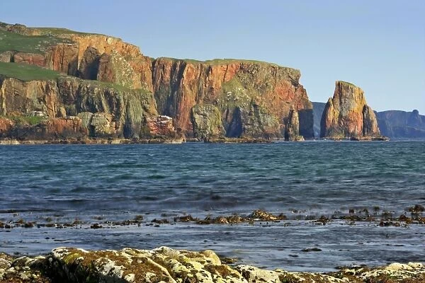 Seascape view from Braewick beach towards red granite cliffs and sea stacks of Stoura Pund and rock formation The Drongs on the right hand side Northmavine, North Mainland, Shetland Isles, Scotland, UK