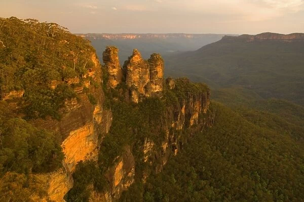 The Three Sisters - famous sandstone formations Three Sisters, seen from Echo Lookout, at sunset. The low sun plunges the scenery in exquisite red light - Blue Mountains National Park, New South Wales, Australia