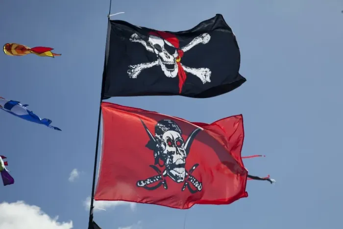 Framed Print : Skull and crossbones flags flying against blue sky - Greenbelt Festival 2010 - Cheltenham - UK