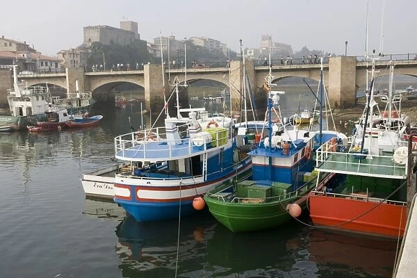 Spanish trawlers moored on quayside near bridge San Vicente de la Barquera Spain