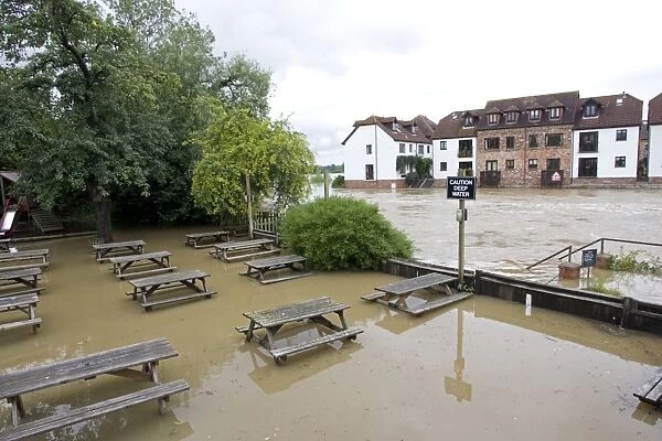 Submerged picnic tables in pub alongside River Avon in flood from Mythe Bridge Tewkesbury Gloucestershire UK during unprecedented flooding of Rivons Avon and Severn above 1947 level