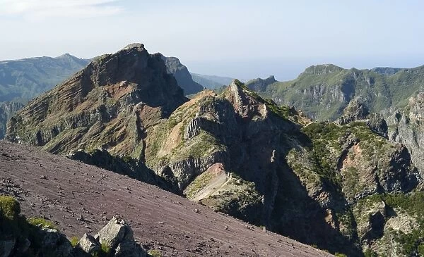 The summit looking north - Pico do Arieiro. At a height of 1818 m. this is the third highest peak on the island of Madeiro. The predominant colours of purple, burnt orange and chocolate brown are a reminder of Madeiro's volcanic origins