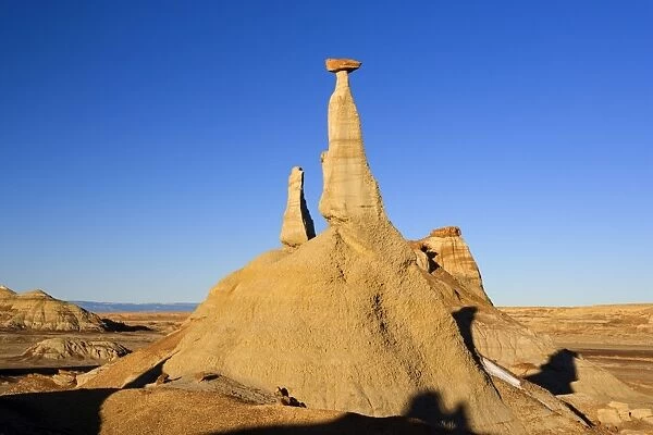 Tall Hoodoo - eroded clay sculptures with rocks balanced on their tops located amidst badlands - Bisti Badlands Wilderness Area - New Mexico - USA