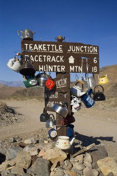Teakettle Junction - wooden road sign at Teakettle Junction, decorated with funny colourful teakettles left by travellers and tourists. On the way to The Racetrack - Death Valley National Park, California, USA