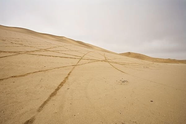 Tracks scar the dunes and Gravel Plains Left by scramblers Near Swakopmund, Namibia, Africa